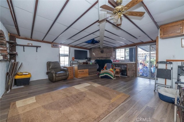 living room featuring ceiling fan, vaulted ceiling, a fireplace, and hardwood / wood-style flooring