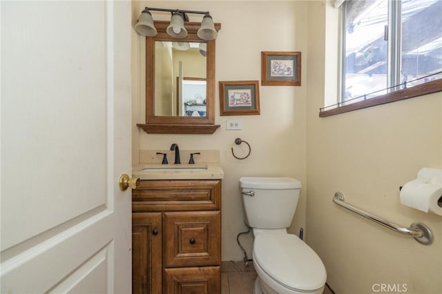 bathroom featuring toilet, vanity, and tile patterned flooring