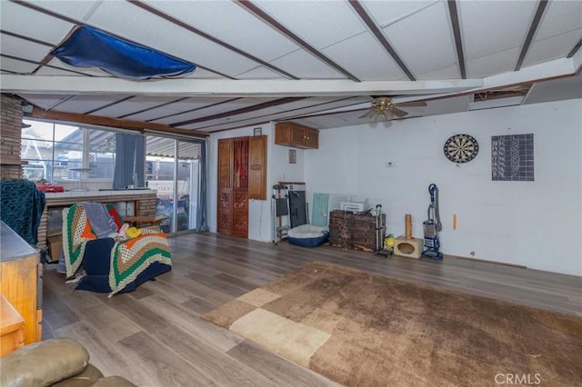 interior space with ceiling fan, lofted ceiling with beams, and hardwood / wood-style flooring