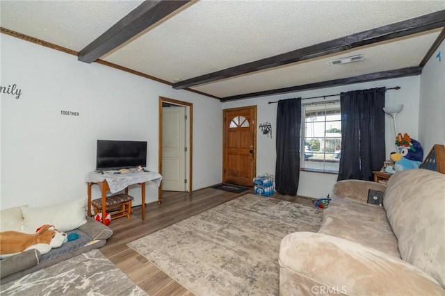 living room with beam ceiling, a textured ceiling, and hardwood / wood-style floors