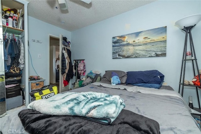 bedroom featuring ceiling fan, a closet, and a textured ceiling