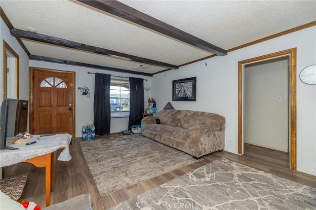 living room with a textured ceiling, wood-type flooring, and beamed ceiling