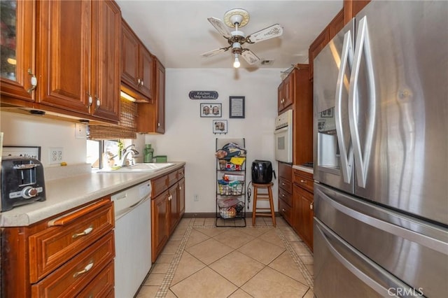 kitchen featuring ceiling fan, light tile patterned floors, sink, and white appliances