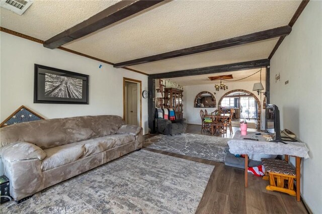 living room with a textured ceiling, dark hardwood / wood-style flooring, and beam ceiling