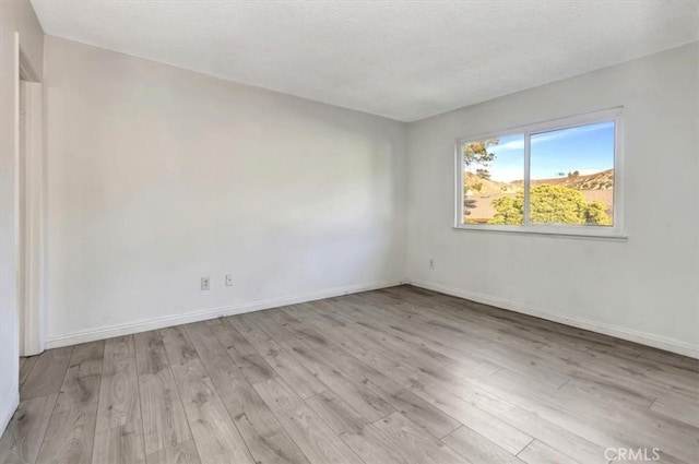 spare room with light hardwood / wood-style flooring