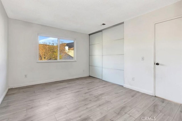 unfurnished bedroom with light wood-type flooring