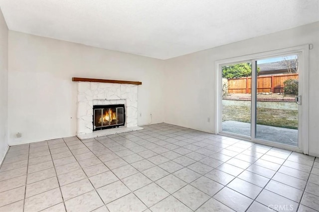 unfurnished living room with light tile patterned floors and a stone fireplace