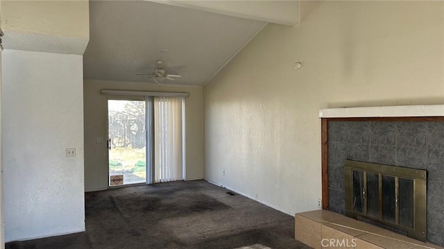 unfurnished living room featuring ceiling fan, vaulted ceiling with beams, a tile fireplace, and carpet flooring