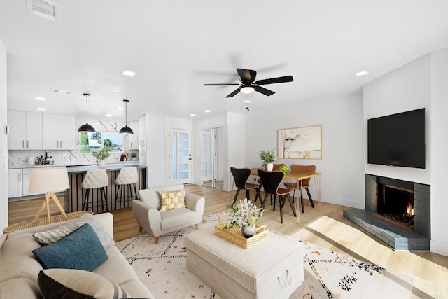 living room featuring light wood-type flooring and ceiling fan