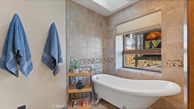 bathroom featuring a washtub and tile walls