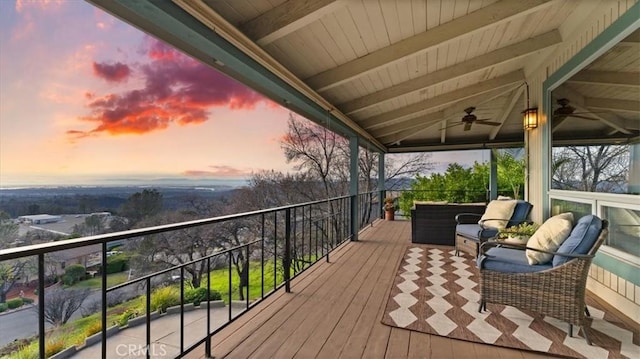 deck at dusk featuring ceiling fan