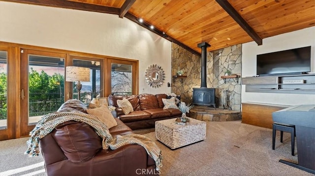 living room with a wood stove, carpet, beam ceiling, and wood ceiling