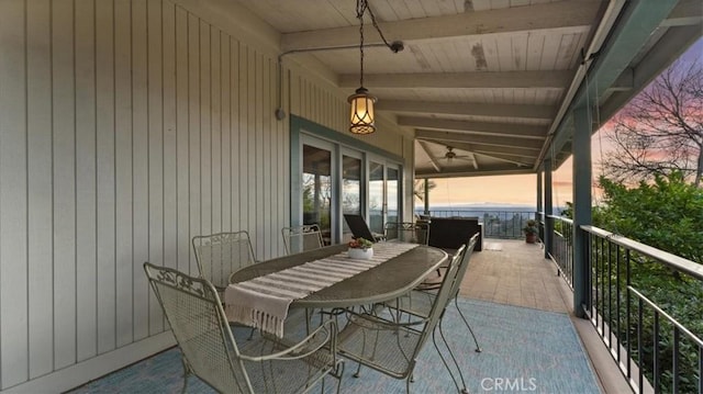 patio terrace at dusk with ceiling fan and a balcony