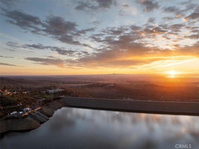 aerial view at dusk featuring a water view