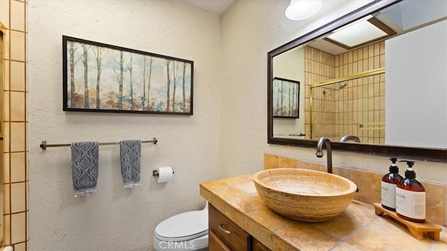 bathroom with a shower, toilet, and vanity