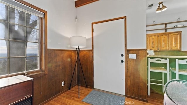 entrance foyer featuring light hardwood / wood-style floors and wood walls