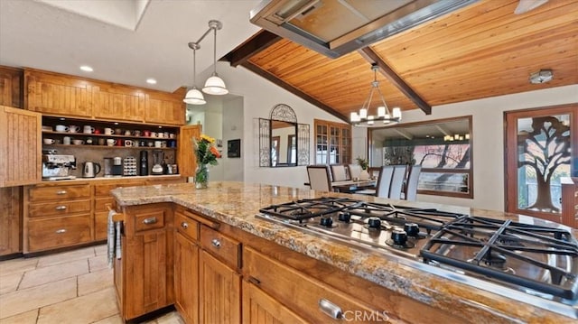 kitchen featuring vaulted ceiling with beams, an inviting chandelier, hanging light fixtures, stainless steel gas cooktop, and light stone countertops