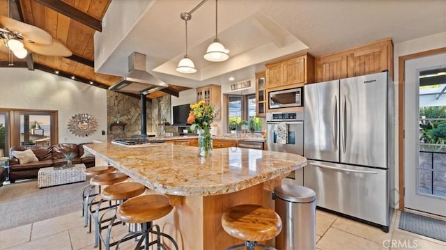 kitchen featuring wood ceiling, a kitchen island, stainless steel appliances, hanging light fixtures, and a breakfast bar area