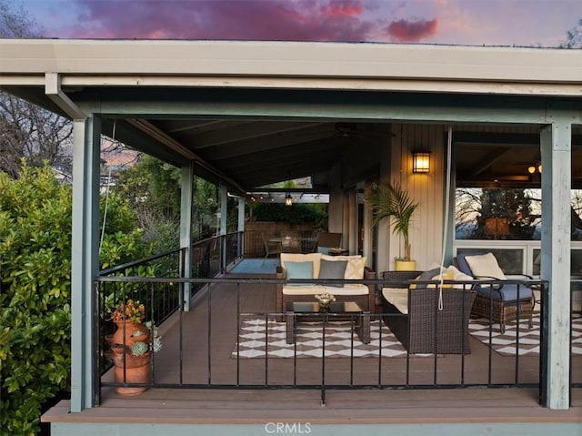 deck at dusk featuring outdoor lounge area