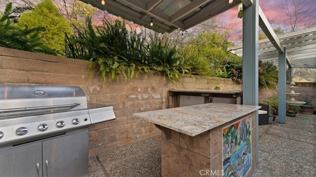 patio terrace at dusk featuring a grill