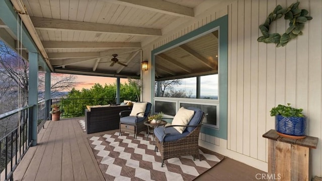 deck at dusk featuring ceiling fan and an outdoor hangout area