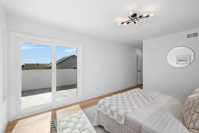 bedroom with access to outside and light wood-type flooring