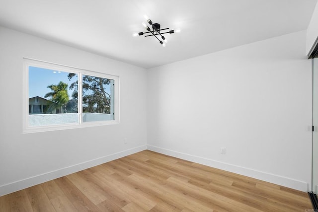 unfurnished room featuring hardwood / wood-style floors and a notable chandelier