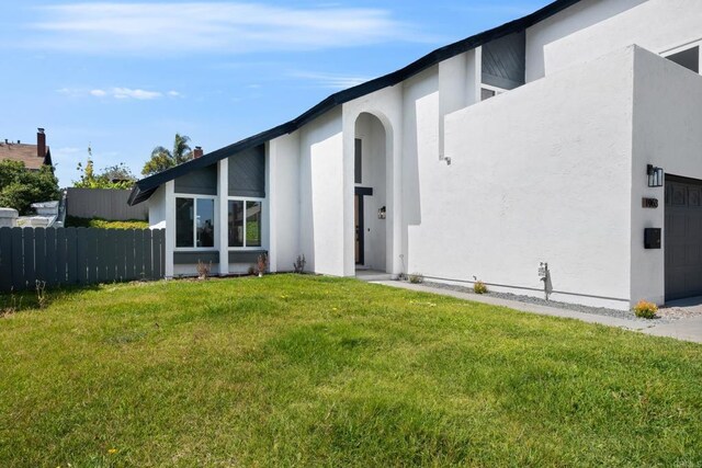 rear view of house featuring a garage and a yard