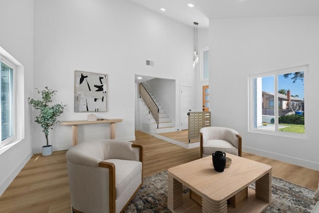 living room featuring hardwood / wood-style flooring, a high ceiling, and a wealth of natural light