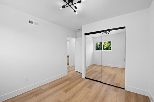 unfurnished bedroom featuring a closet and light hardwood / wood-style flooring