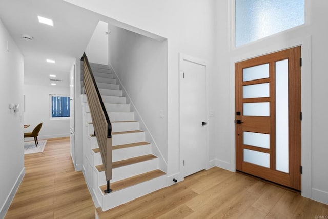 foyer entrance featuring a high ceiling and light wood-type flooring