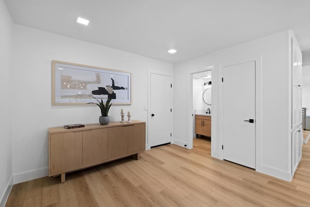 interior space featuring ensuite bathroom, sink, and light hardwood / wood-style flooring