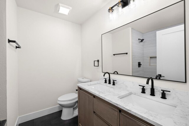 bathroom with walk in shower, tile patterned flooring, vanity, and toilet