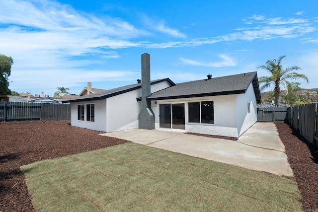 rear view of property with a lawn and a patio area