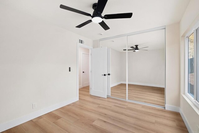 unfurnished bedroom with ceiling fan, a closet, and light hardwood / wood-style floors