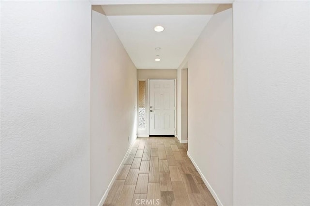 hallway featuring baseboards and wood finished floors