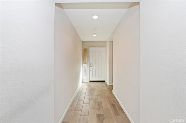 hall with light wood finished floors and baseboards