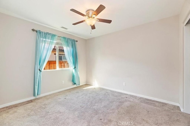 carpeted empty room featuring a ceiling fan, baseboards, and visible vents