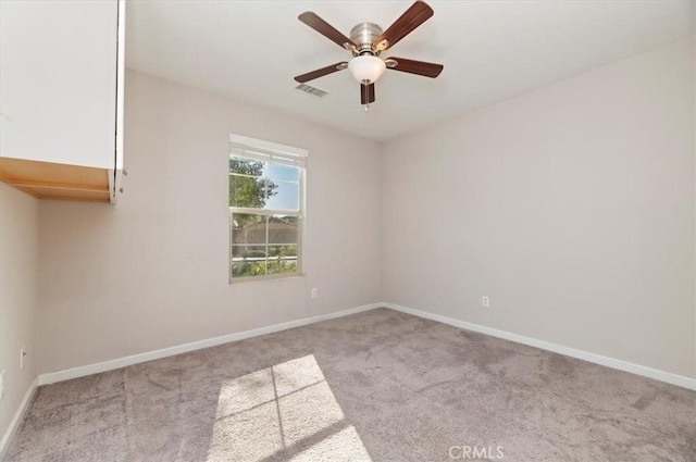 empty room featuring visible vents, carpet, baseboards, and ceiling fan