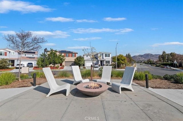 view of patio / terrace featuring a mountain view, a residential view, and an outdoor fire pit