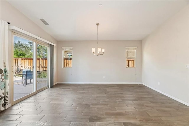 unfurnished room featuring an inviting chandelier, baseboards, visible vents, and wood tiled floor