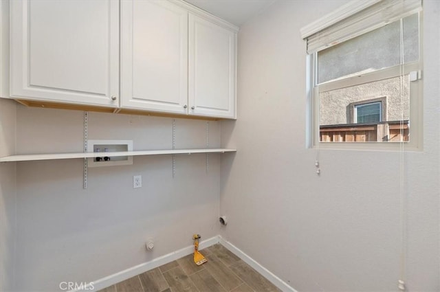 laundry room with baseboards, gas dryer hookup, hookup for a washing machine, wood finished floors, and cabinet space