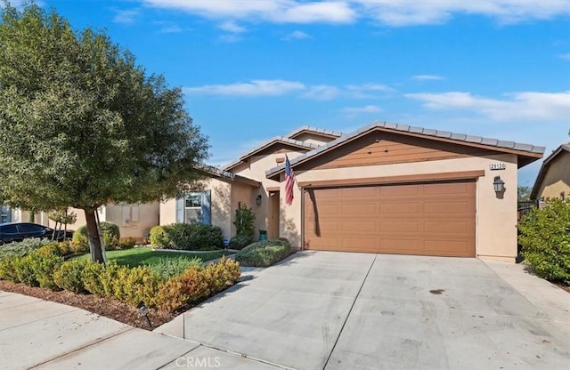 single story home with stucco siding, an attached garage, and concrete driveway