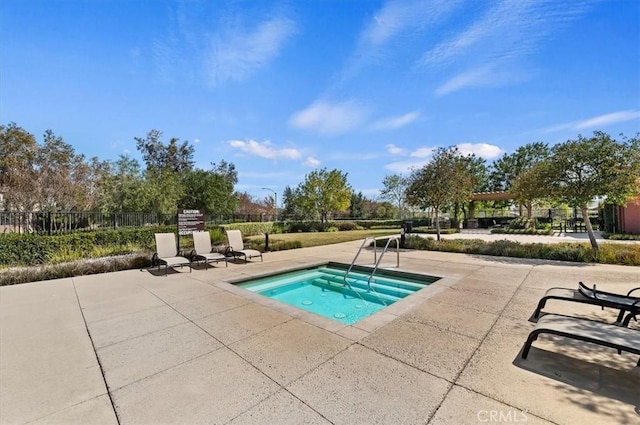 view of swimming pool featuring a patio, fence, and a hot tub