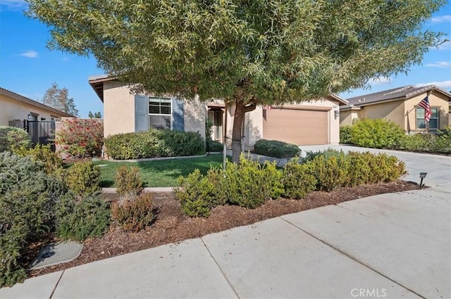 view of front of home with driveway, an attached garage, and stucco siding