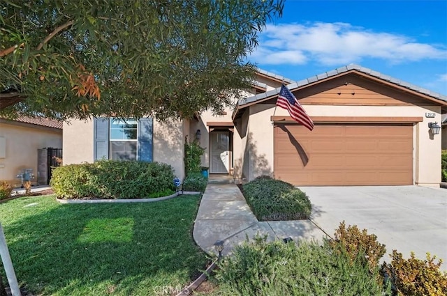 view of front of home featuring a garage, driveway, a front lawn, and stucco siding