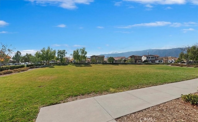 surrounding community with a mountain view and a yard