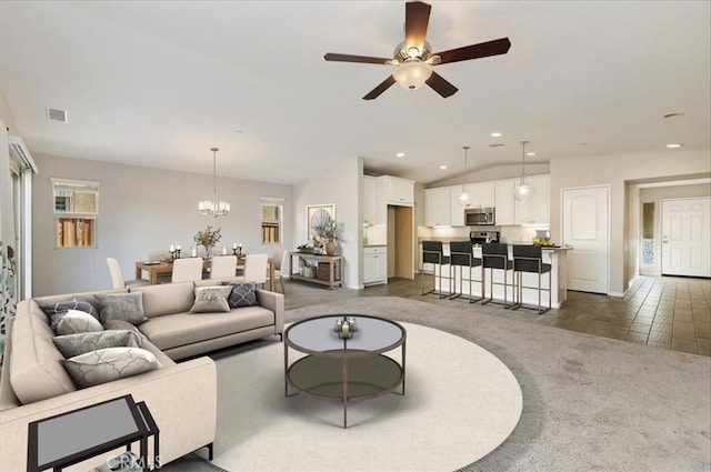 living area featuring recessed lighting, visible vents, lofted ceiling, and ceiling fan with notable chandelier