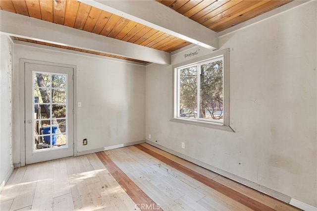 spare room with a wealth of natural light, beamed ceiling, wood ceiling, and light wood-type flooring