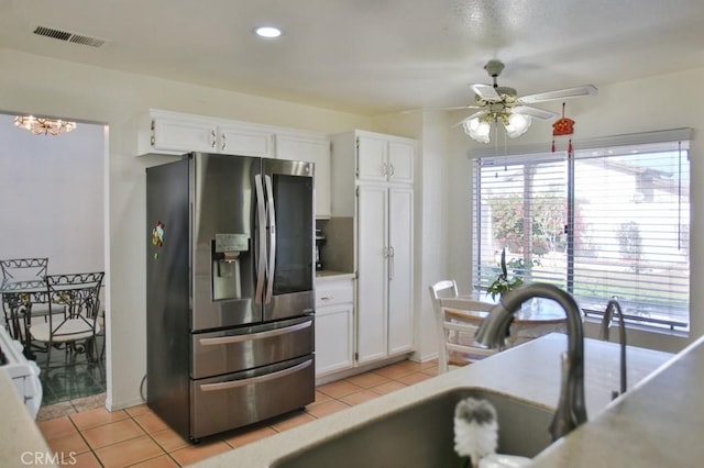 kitchen with visible vents, light countertops, white cabinetry, and stainless steel fridge with ice dispenser